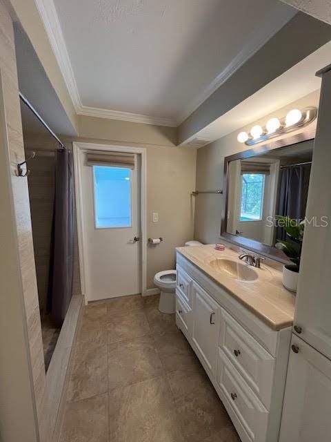 bathroom with vanity, crown molding, curtained shower, and toilet