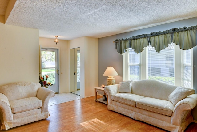 living room featuring a textured ceiling and light wood-type flooring