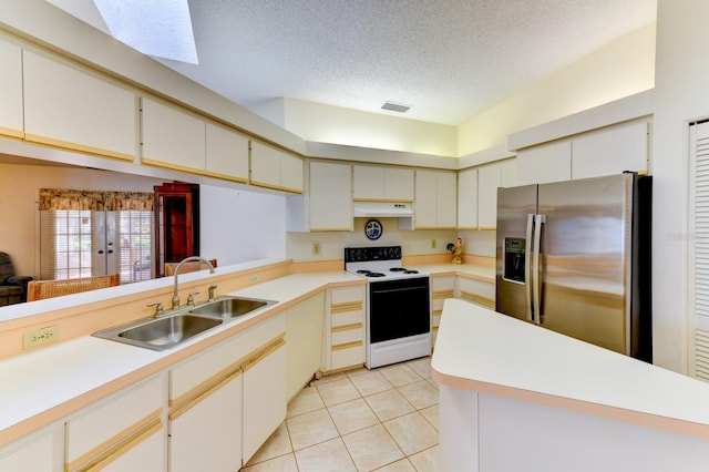 kitchen featuring a textured ceiling, sink, light tile patterned floors, stainless steel fridge with ice dispenser, and white range with electric cooktop