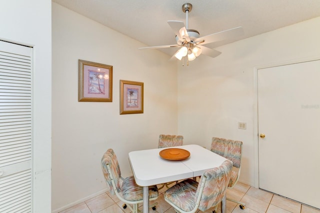 tiled dining space with ceiling fan