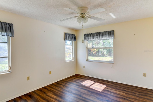 unfurnished room featuring a textured ceiling, dark hardwood / wood-style flooring, ceiling fan, and a healthy amount of sunlight