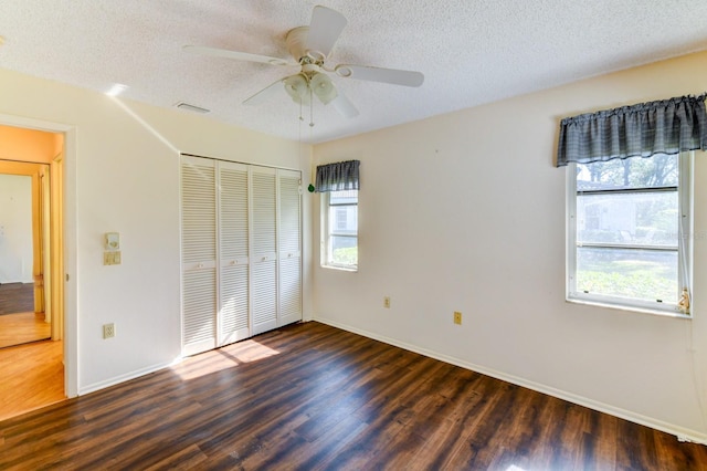 unfurnished bedroom with dark hardwood / wood-style floors, ceiling fan, a textured ceiling, and a closet