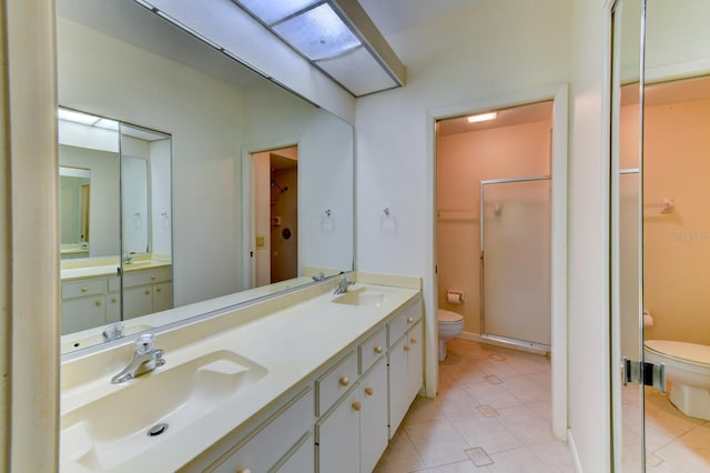 bathroom with tile patterned floors, vanity, an enclosed shower, and toilet