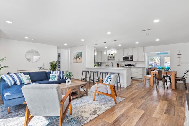 living room with sink and light hardwood / wood-style floors