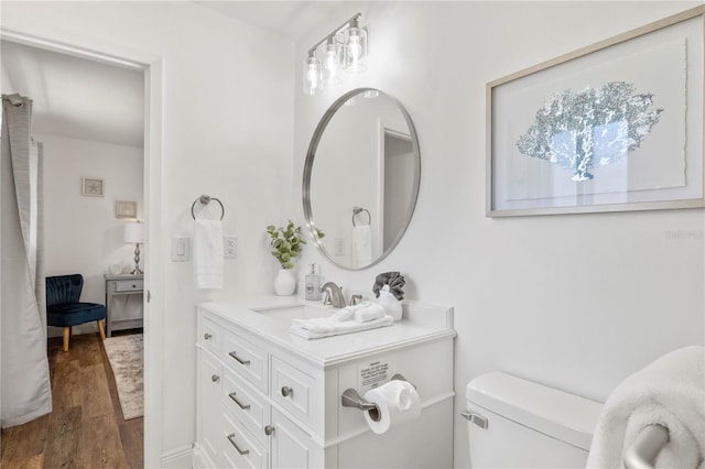 bathroom with vanity, toilet, and hardwood / wood-style floors