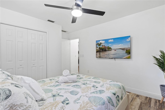 bedroom with hardwood / wood-style flooring, ceiling fan, and a closet