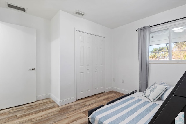 bedroom with light hardwood / wood-style floors and a closet