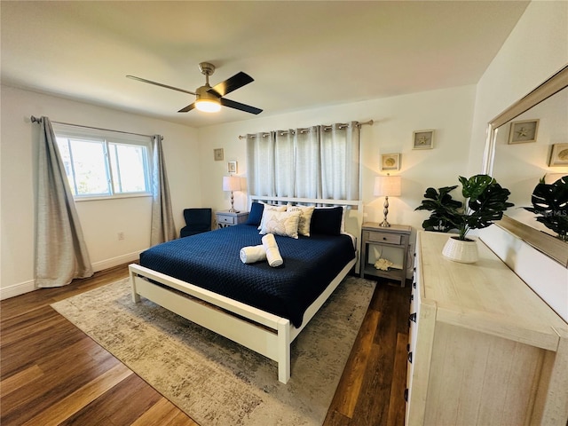 bedroom with dark hardwood / wood-style flooring and ceiling fan