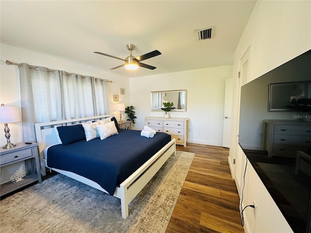 bedroom with dark hardwood / wood-style floors and ceiling fan