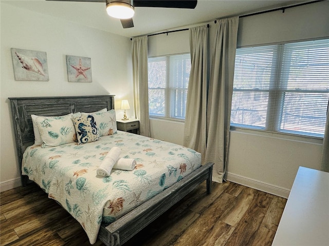 bedroom featuring multiple windows, dark wood-type flooring, and ceiling fan