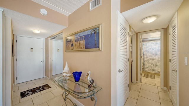 entryway featuring light tile patterned floors and a textured ceiling