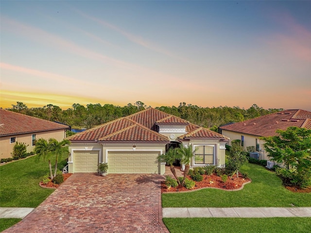 mediterranean / spanish-style house featuring a lawn and a garage