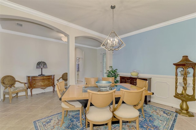 dining area featuring light tile patterned floors, a chandelier, and ornamental molding