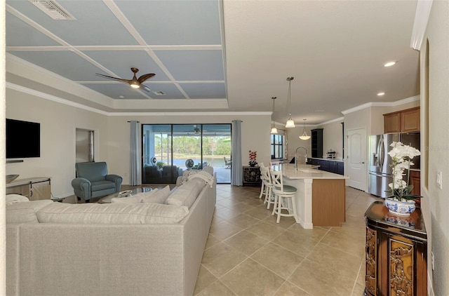 tiled living room featuring ceiling fan, ornamental molding, sink, and coffered ceiling