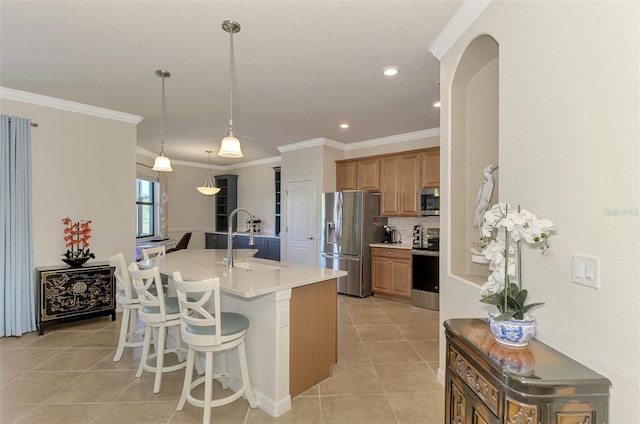 kitchen featuring a kitchen bar, appliances with stainless steel finishes, a kitchen island with sink, crown molding, and sink