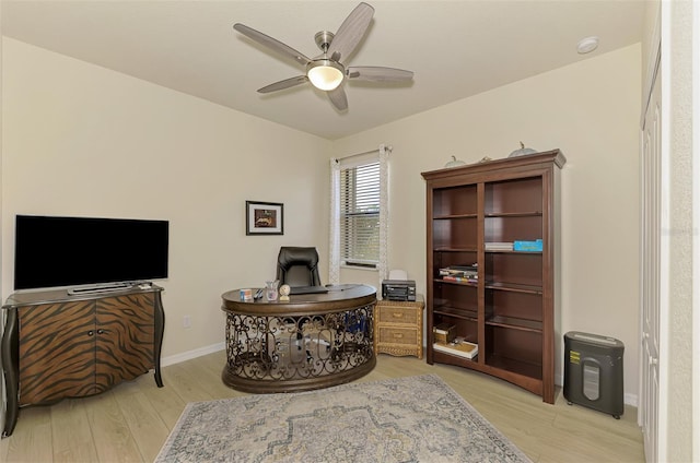 home office featuring ceiling fan and light hardwood / wood-style flooring