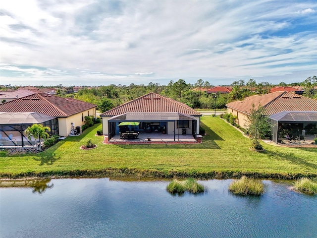 rear view of property with glass enclosure, a patio area, a yard, and a water view