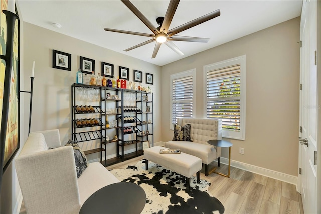 sitting room with ceiling fan and light hardwood / wood-style flooring