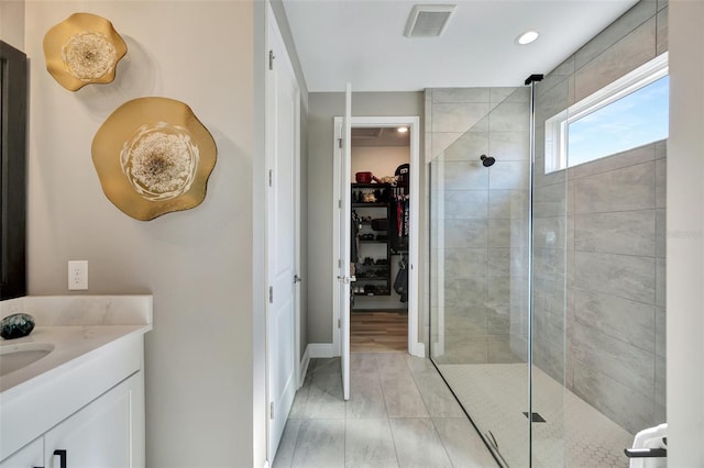 bathroom with a tile shower, hardwood / wood-style floors, and vanity