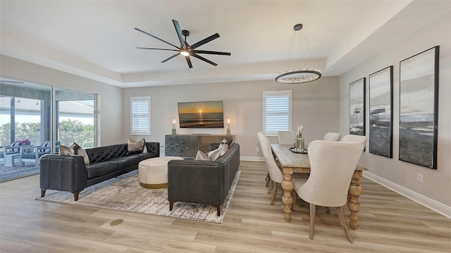 17744 Savory Mist Cir, Bradenton, FL 34211 - living area with a raised ceiling, wood finished floors, ceiling fan with notable chandelier, and baseboards