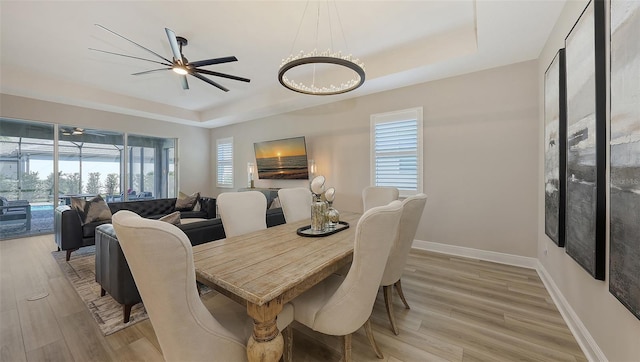 17744 Savory Mist Cir, Bradenton, FL 34211 - dining room with light wood finished floors, ceiling fan, baseboards, and a raised ceiling