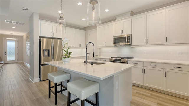 17744 Savory Mist Cir, Bradenton, FL 34211 - kitchen featuring visible vents, a sink, appliances with stainless steel finishes, pendant lighting, and decorative backsplash