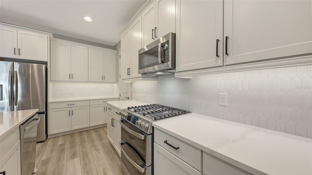 17744 Savory Mist Cir, Bradenton, FL 34211 - kitchen featuring backsplash, light countertops, light wood-type flooring, and stainless steel appliances