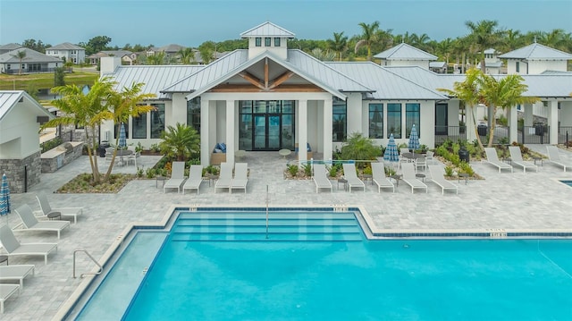 17744 Savory Mist Cir, Bradenton, FL 34211 - rear view of property featuring a standing seam roof, a community pool, a patio, metal roof, and french doors