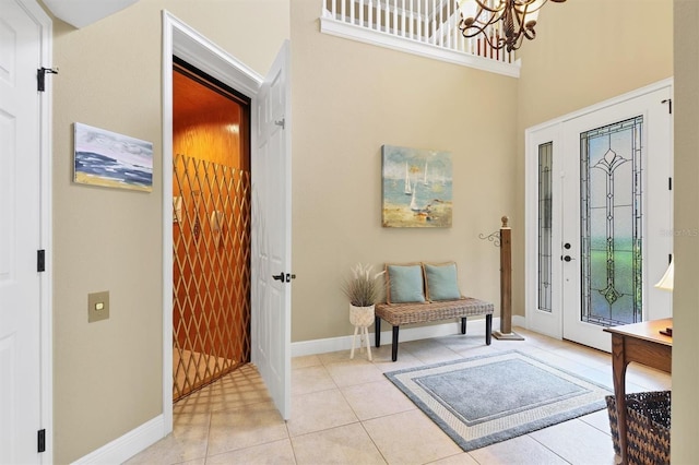 entrance foyer with an inviting chandelier, a high ceiling, and light tile patterned floors