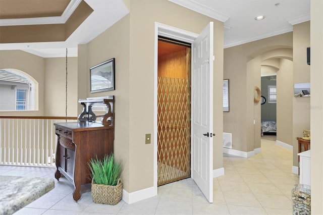 hallway with crown molding and light tile patterned floors