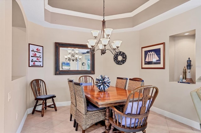 tiled dining room featuring a raised ceiling, ornamental molding, and an inviting chandelier