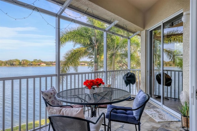 sunroom featuring a water view