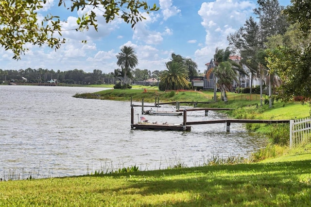 view of dock with a water view and a lawn