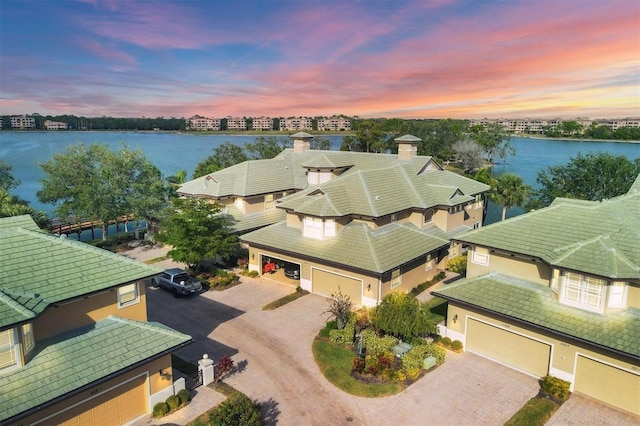 aerial view at dusk featuring a water view