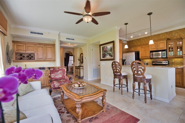 tiled living room featuring track lighting, ceiling fan, and crown molding