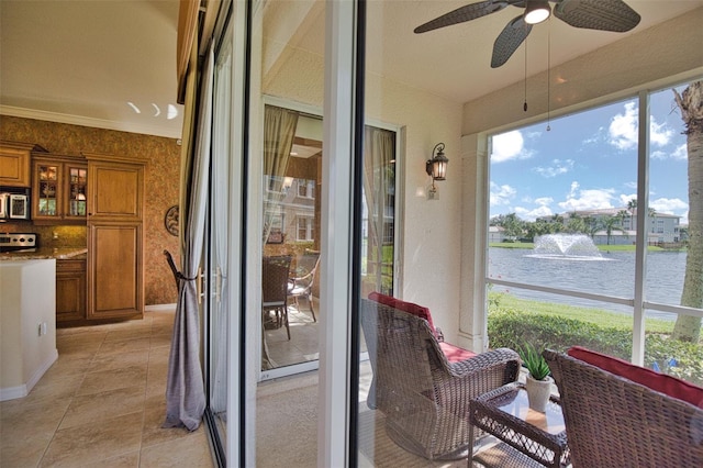 sunroom / solarium with ceiling fan and a water view