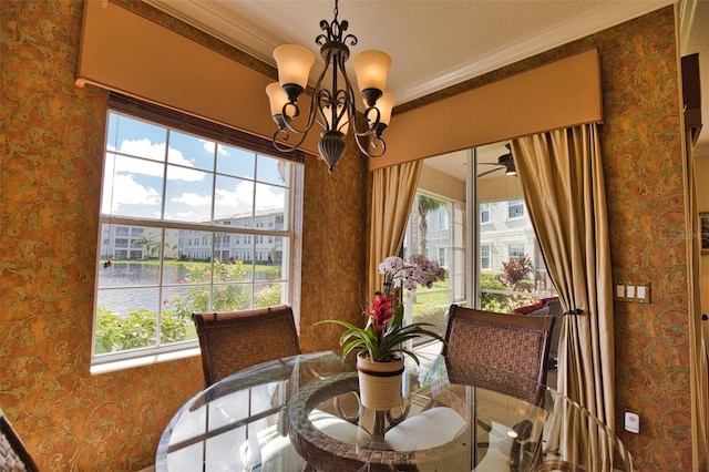 dining space featuring a water view, a wealth of natural light, and crown molding