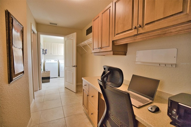 office area with independent washer and dryer, light tile patterned flooring, built in desk, and a textured ceiling