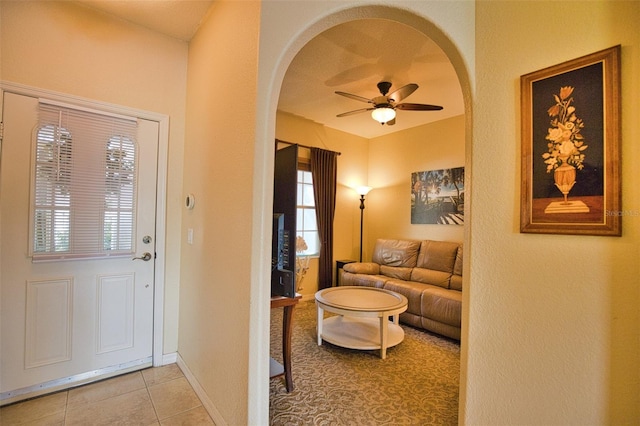 tiled entryway featuring ceiling fan