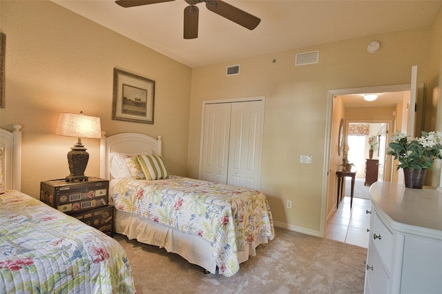 carpeted bedroom with ceiling fan and a closet