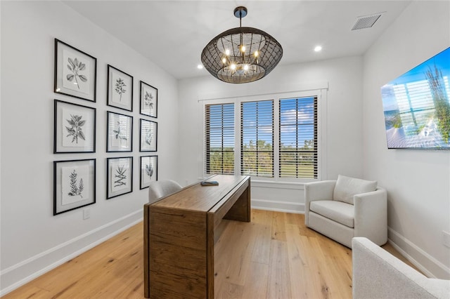 office featuring a notable chandelier, light wood-type flooring, and a wealth of natural light