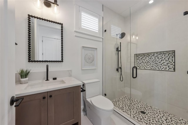 bathroom featuring vanity, toilet, and an enclosed shower