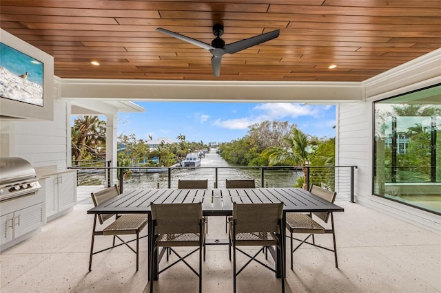 view of patio with grilling area, ceiling fan, and a water view