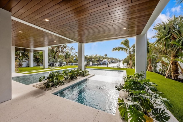 view of pool with a patio and a lawn