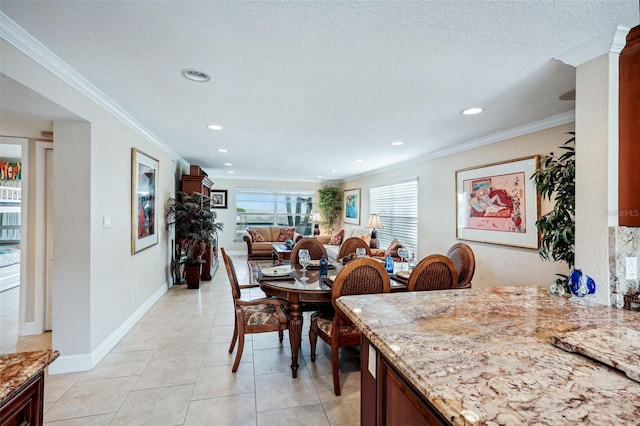 dining area with ornamental molding, a textured ceiling, and light tile patterned floors