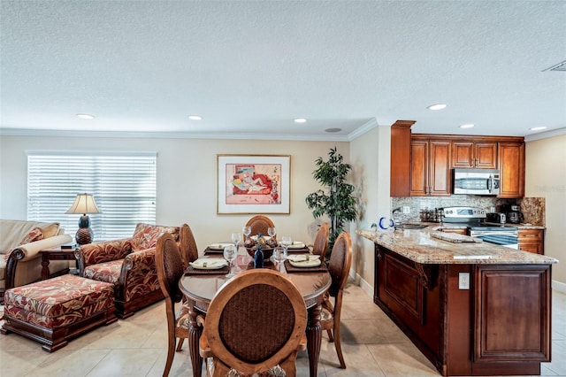 dining room featuring light tile patterned floors, a textured ceiling, and ornamental molding