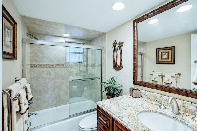 full bathroom with shower / bath combination with glass door, vanity, and toilet