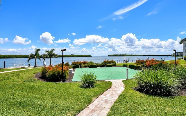 view of swimming pool with a yard and a water view