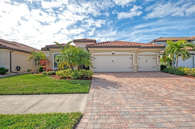 mediterranean / spanish-style home with a garage and a front lawn