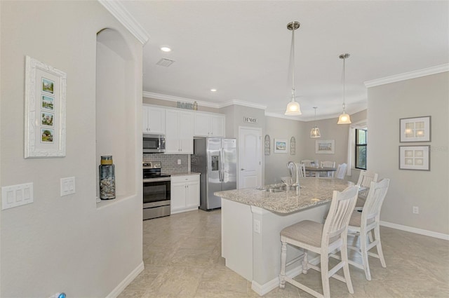 kitchen featuring sink, white cabinets, appliances with stainless steel finishes, and a kitchen island with sink